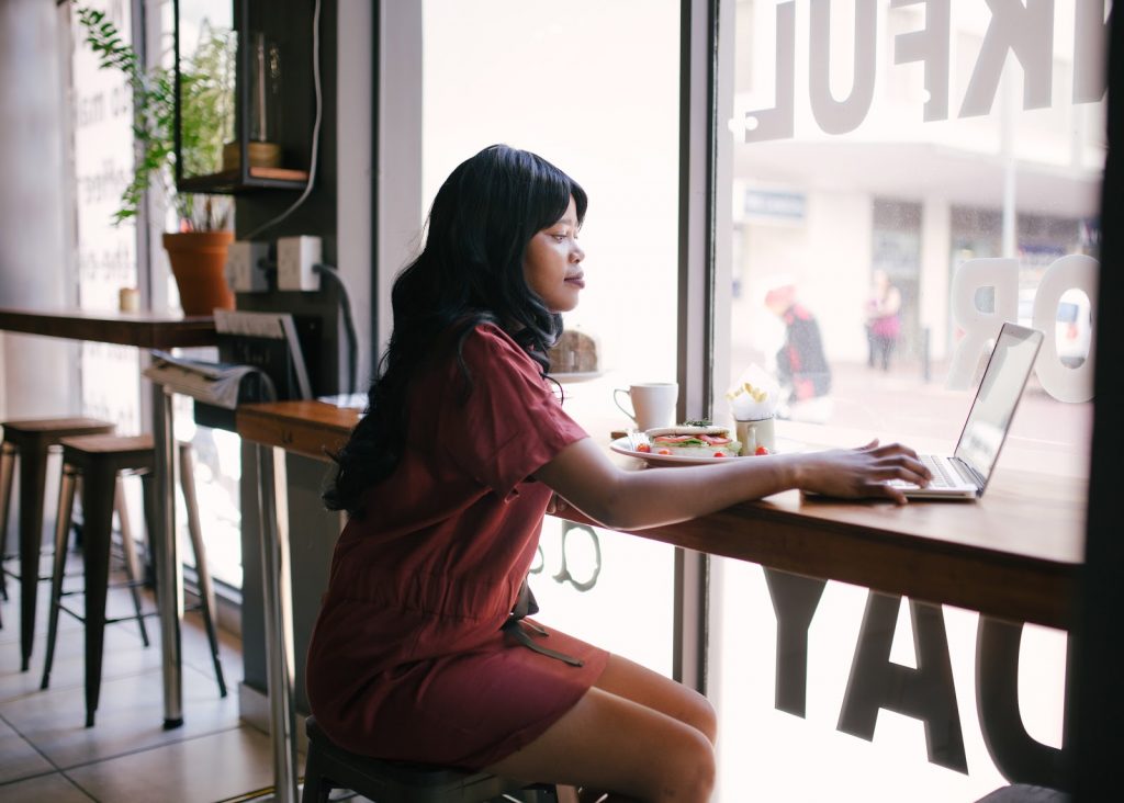 a woman sitting at a table with a laptop