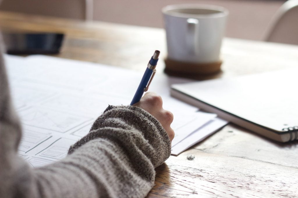 a person writing on a piece of paper