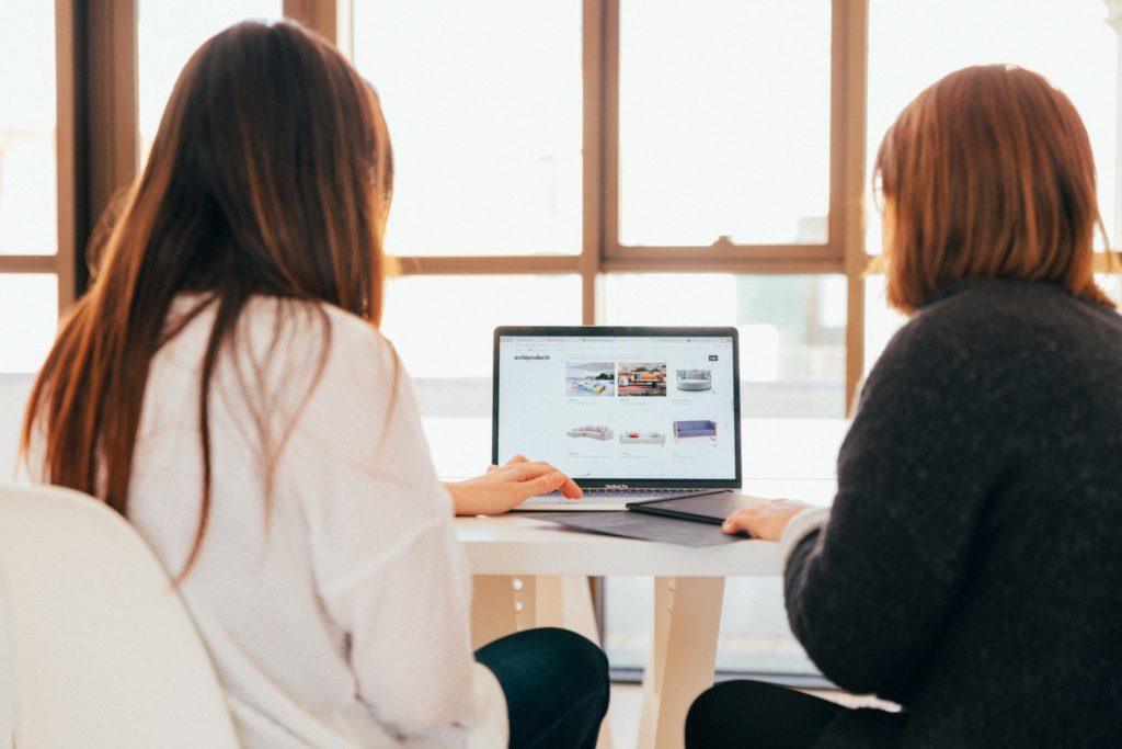 a woman and a woman looking at a laptop