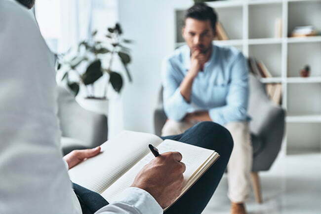 a person sitting in a chair with a pen and a paper