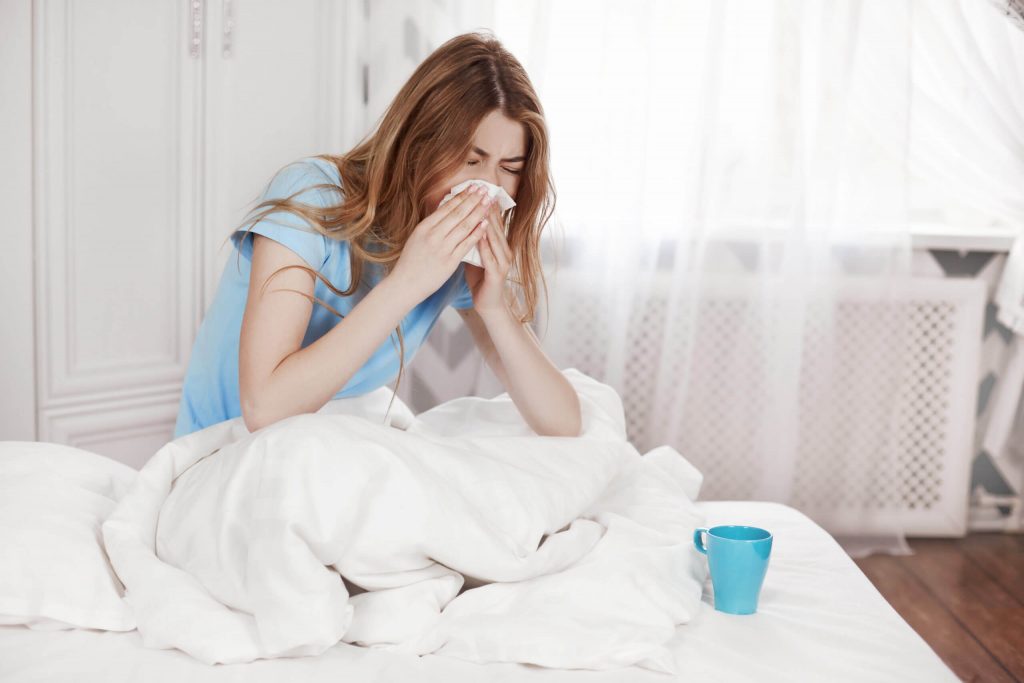 a woman lying in bed with her hands on her face