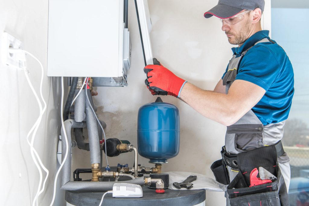 a man wearing a blue shirt and working on a machine