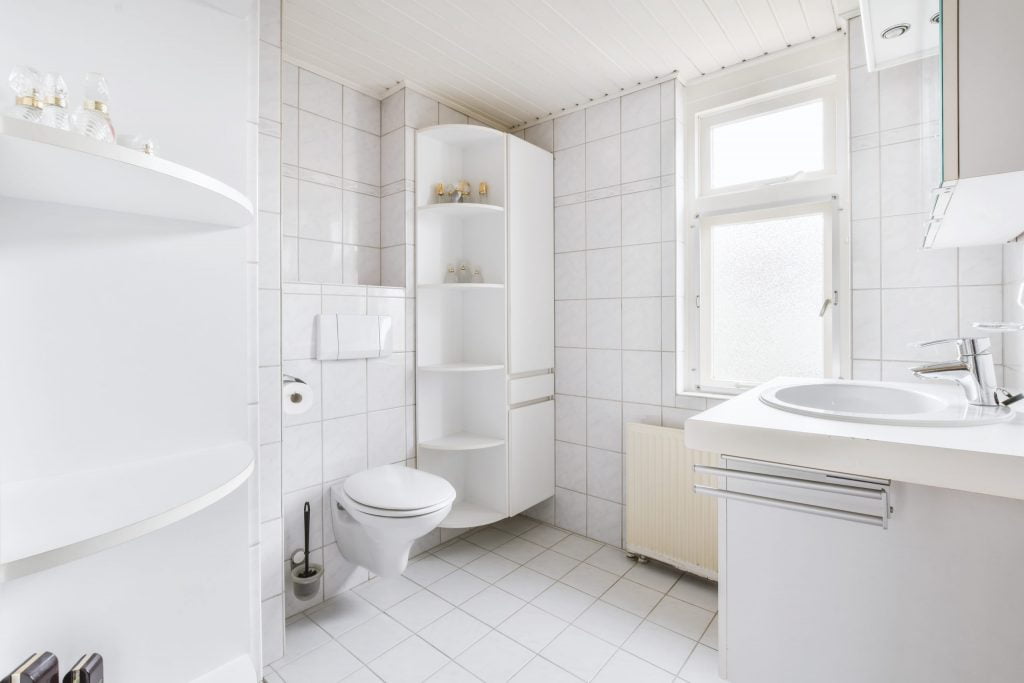 a bathroom with a toilet sink and a mirror