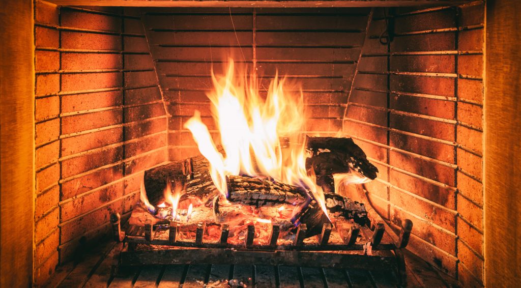 a person sitting on a chair in front of a fire