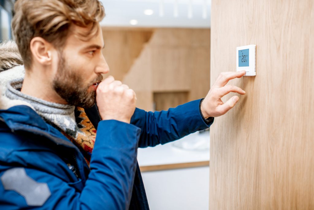 a man holding a phone next to a door