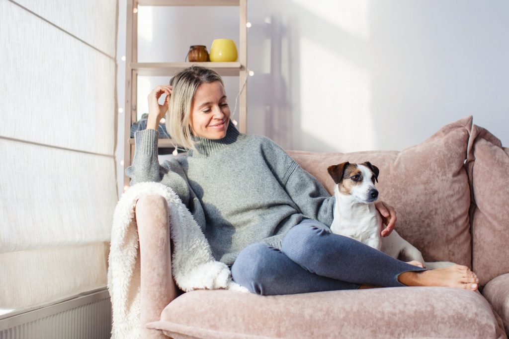 a person sitting on a couch with a dog