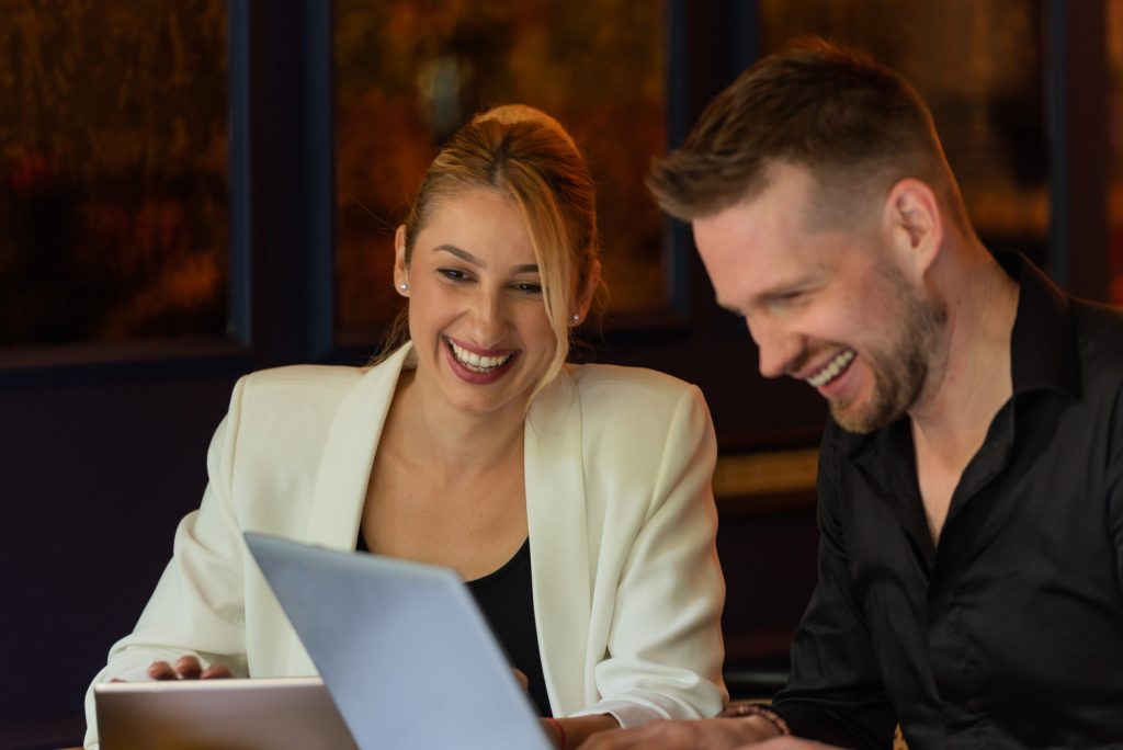 a man and a woman looking at a laptop