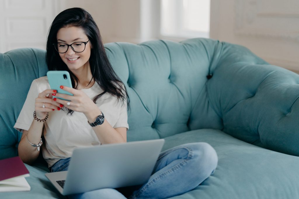 a person and a child on a couch looking at a cell phone