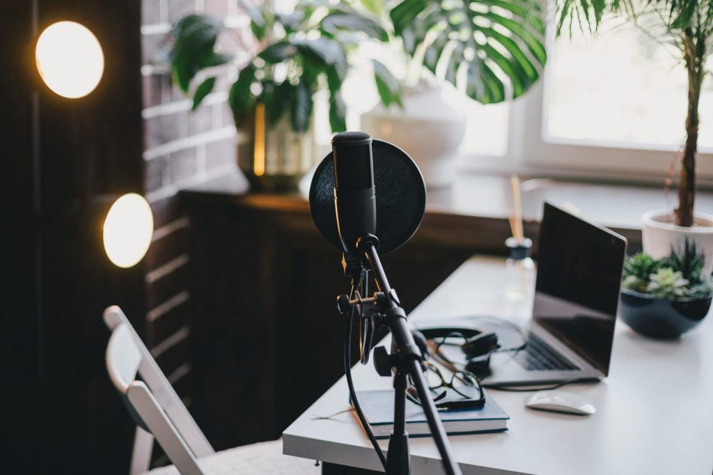 Professional equipment for recording podcast: microphone, earphones and laptop in a studio