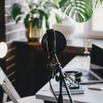 Professional equipment for recording podcast: microphone, earphones and laptop in a studio