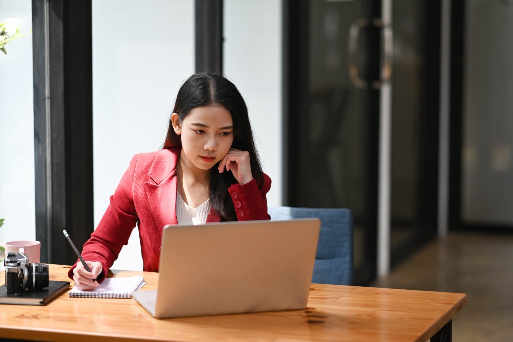 Asian businesswoman concentrated working while sitting in her office room.