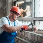 contractor wielding a hammer to destroy old brick       utc scaled