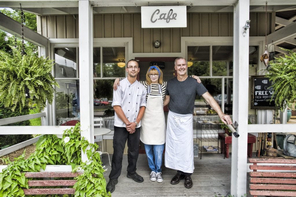 cafe owner and partners posing in front of restaur       utc scaled