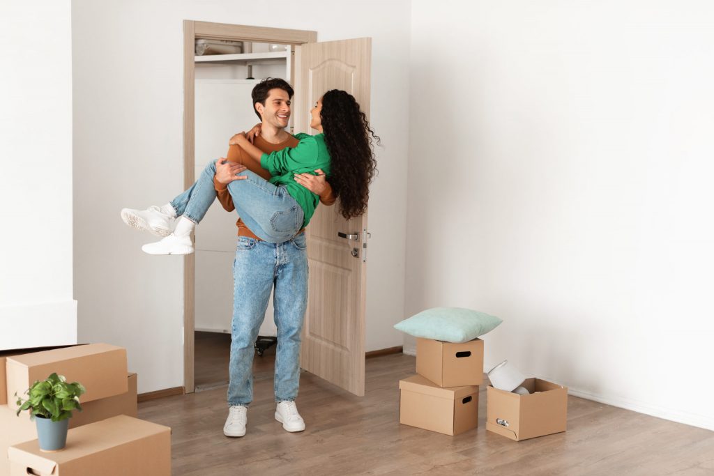 happy millennial couple celebrating moving day in       utc scaled