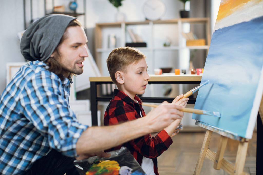 teacher and schoolboy painting with brushes on can       utc scaled